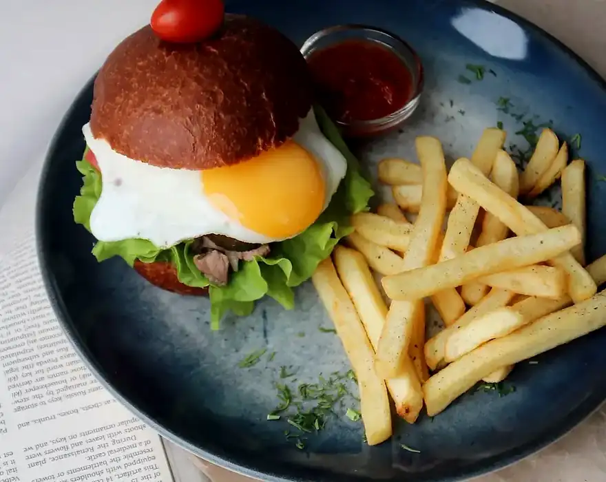 Burger and fries in a dark restaurant setting